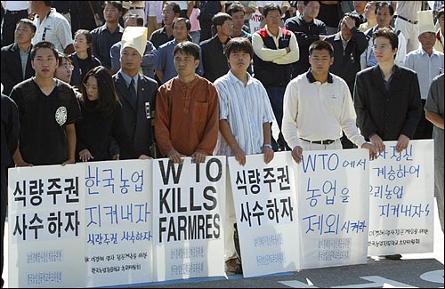 지난 9월 11일 세계무역기구(WTO) 각료회의가 열리는 멕시코 칸쿤에서 자결한 고 이경해씨의 세계농민장이 20일 오전 서울 송파구 올림픽공원에서 엄수됐다. 고인의 막내딸 이지혜씨가 다니는 한국농업전문학교 학생들이 고인을 추모하는 피켓을 들고 있다. 